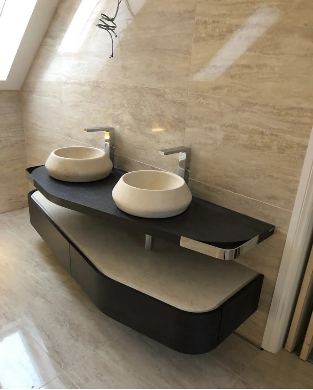 Bespoke floating vanity with twin stone vessel basins and travertine walls
