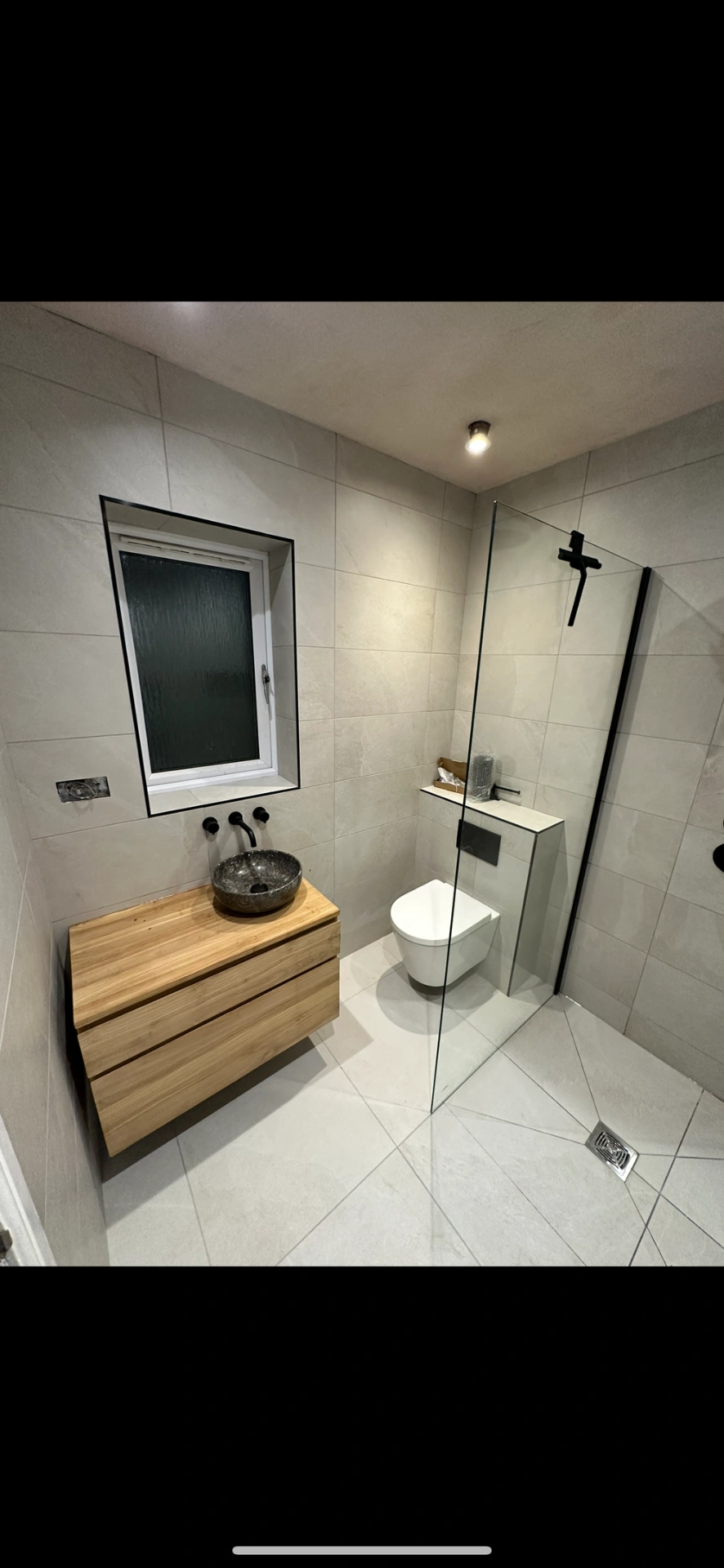 Shower room with floating oak vanity, framed mirror and matte black fittings