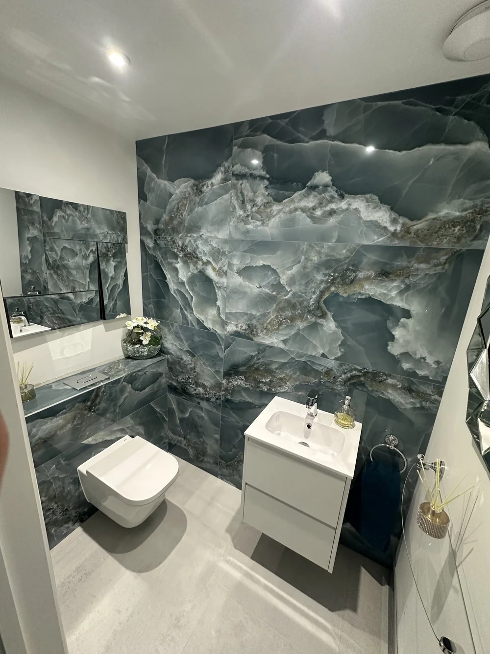 Powder room with blue onyx marble feature wall and floating vanity