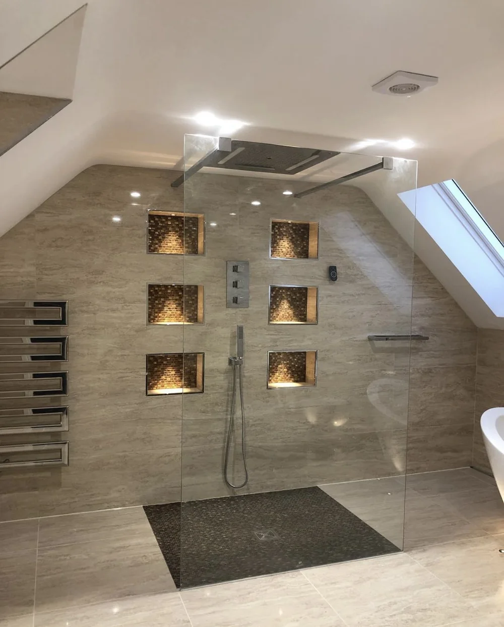 Walk-in wet room with glass screen, mosaic tray and feature niches