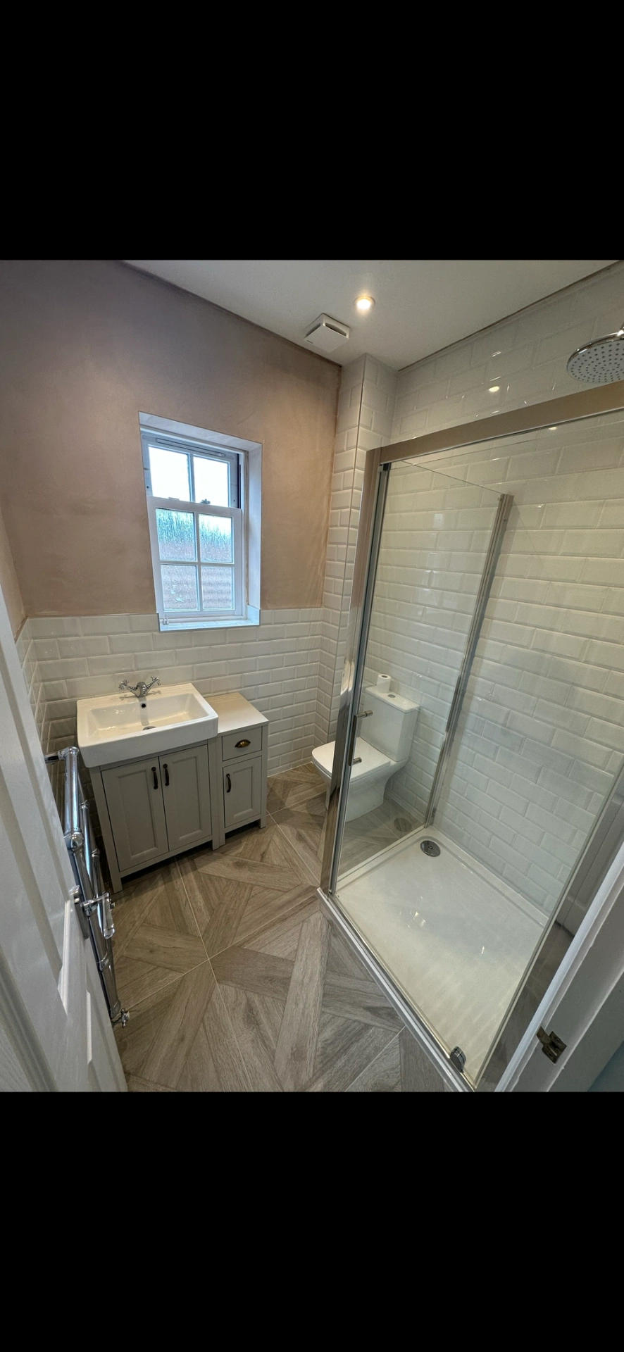 Compact ensuite with walk-in shower, metro tiles and chevron wood floor