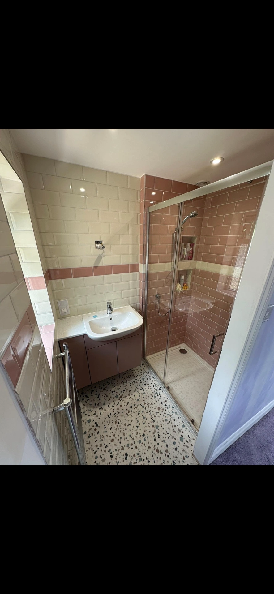 Pink and cream metro-tiled shower room with terrazzo floor