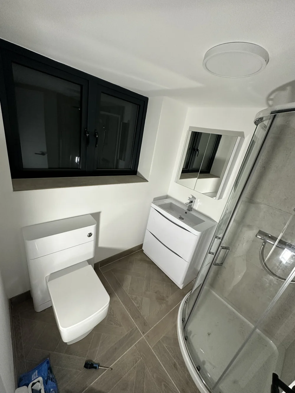 Compact ensuite with concealed cistern WC, vanity and quadrant shower