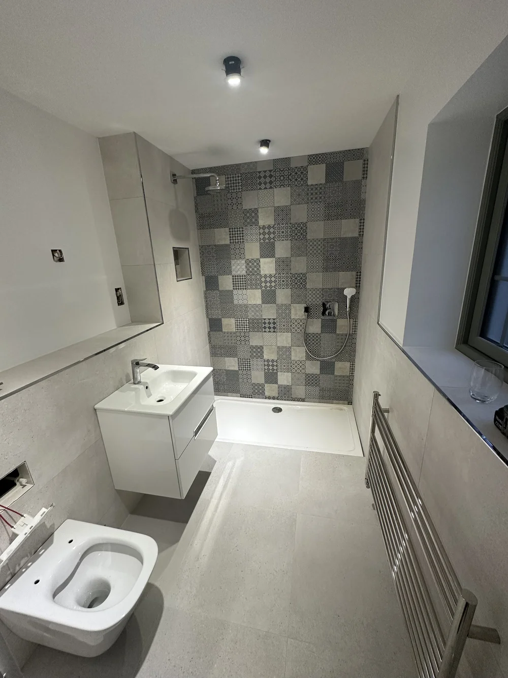 Bathroom with patchwork mosaic feature wall in walk-in shower area